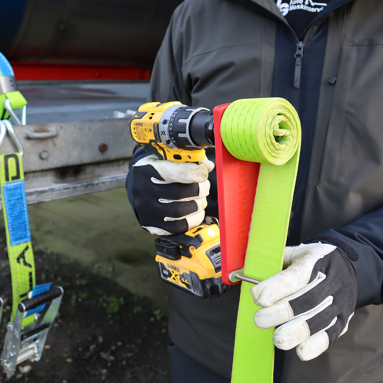 Cordless Drill Attachment Fast Strap Winder held in hand, showcasing its red polymer body and robust handle, designed for efficient strap winding with a drill.